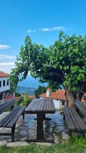 a wooden picnic table in front of a tree at Guesthouse Eleni in Palaios Panteleimon