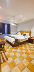 a bedroom with a large bed and a tiled floor at Hotel Nova Star in Rajkot