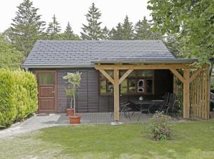 a small cabin with a patio and a table at Ferienhaus "Oybinblick" in Oybin