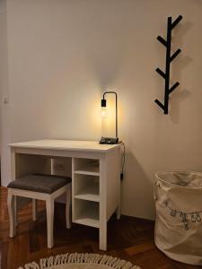 un escritorio blanco con lámpara y taburete en Apartment Citadela, en Marina