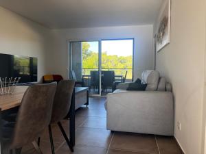 a living room with a couch and a table and a dining room at T2 Porticcio neuf in Porticcio