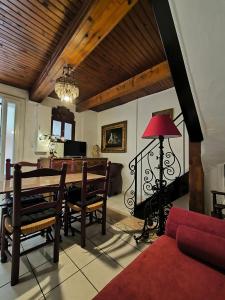 a living room with a table and a red lamp at Maison enchanteresse au cœur de ville de Marseillan in Marseillan