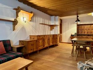 a dining room with a table and wooden cabinets at Spacious Alpine Retreat & Parking in Cortina dʼAmpezzo