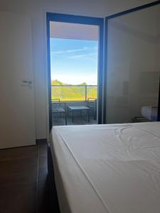a bedroom with a bed and a sliding glass door at T2 Porticcio neuf in Porticcio