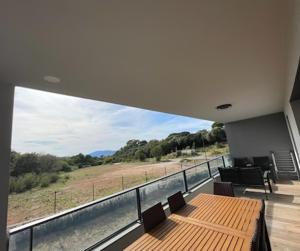 a house with a balcony with a table and chairs at T2 Porticcio neuf in Porticcio