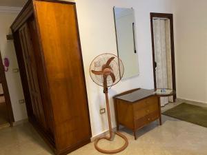 a room with a fan next to a wooden cabinet at Bianchi Hotel in Alexandria
