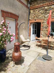 eine Terrasse mit einem Tisch und einer Vase auf dem Boden in der Unterkunft Appartement proche aéroport & indret in Bouguenais