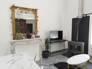 ein Wohnzimmer mit Kamin und Spiegel in der Unterkunft Appartement proche aéroport & indret in Bouguenais + 14 Fotos