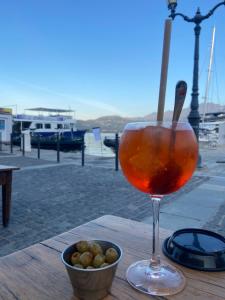 a drink sitting on a wooden table next to a bowl of food at Corso di Mare Calvi in Calvi