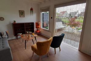 a living room with a table and chairs at Tuinhuis Vijverzicht in Leeuwarden