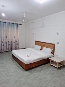 a bedroom with a large bed and a table at Jade luxury apartments in Galu