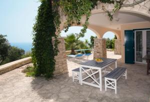 un tavolo e sedie seduti fuori da una casa di Villa Le Terrazze plus Pool a Gagliano del Capo