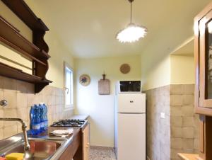 a kitchen with a white refrigerator and a sink at Cozy & Spacious Casa Friulana in Flambruzzo