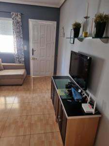 a living room with a tv and a couch at Casa La Florida in Orihuela