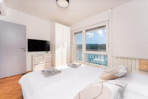 a bedroom with two beds and a large window at Apartment Stella in Rabac