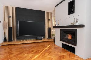 a living room with a fireplace and a flat screen tv at Apartment Stella in Rabac
