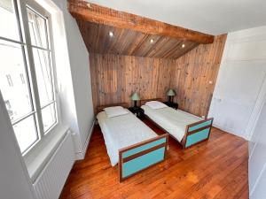 ein Dachzimmer mit zwei Betten und einem Fenster in der Unterkunft Appartement centre-ville très spacieux avec 4 chambres in La Tour-du-Pin