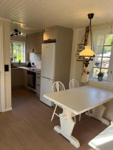 eine Küche mit einem weißen Tisch und einem weißen Kühlschrank in der Unterkunft Haukedalen mountain panorama river view in Holsen
