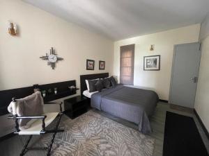 a bedroom with a bed and a chair in it at Bhurban Valley Cottages 2 in Bhurban +29 photos