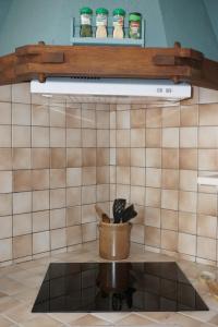 una cucina con un portautensili su una parete piastrellata di Le Cocon Asprion a Aspres-lès-Corps Altre 42 foto