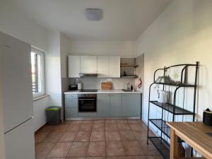 a kitchen with white cabinets and a tile floor at Apartmani Gemma in Premantura