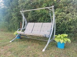 a swing in a yard with two potted plants at Small Robinson House 250m to the sea in Peroj