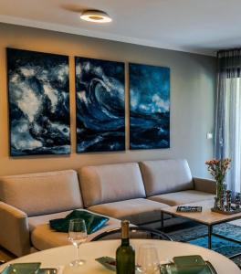 a living room with a couch and paintings on the wall at Luxe apartment Del Mare in Podstrana