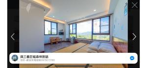 a living room with a couch and windows at 巨缿民宿巨象民宿 in Sanyi