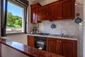 a kitchen with wooden cabinets and a sink and a window at Casa Letizia - Welchome in Rocca San Giovanni