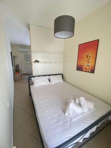 a bed in a room with towels on it at Theros Kalamitsa Apartment in Kavála