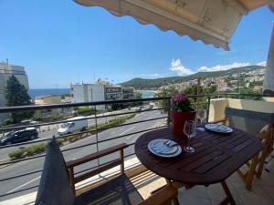 a table on a balcony with a view of a city at Theros Kalamitsa Apartment in Kavála