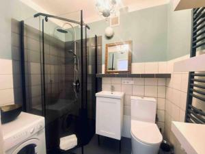 a bathroom with a toilet and a sink and a shower at Stanislawa Augusta by P&J Apartments in Warsaw +15 photos