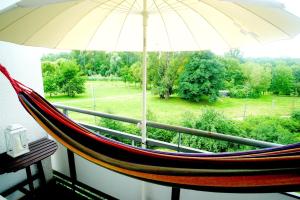 a hammock sitting on a balcony with an umbrella at Stanislawa Augusta by P&J Apartments in Warsaw