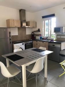 eine Küche mit einem Tisch und Stühlen darin in der Unterkunft MINI VILLA entre mer et montagne PALAVESA in Porto-Vecchio