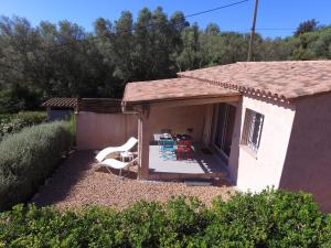 ein Haus mit einer Terrasse mit Stühlen und einem Tisch in der Unterkunft MINI VILLA entre mer et montagne PALAVESA in Porto-Vecchio