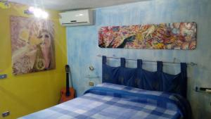 a bedroom with a bed and paintings on the wall at Albergo Diffuso Culturart House in Agrigento