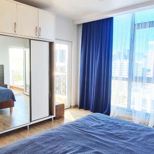 - une chambre avec un lit bleu et des rideaux bleus dans l'établissement Seaside 2-Room 3-Balconies Apt#12 Stunning View, à Batoumi