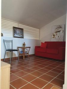 a living room with a red couch and a table at Villa con vista mare in Stalettì