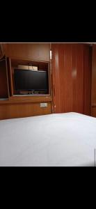 a bedroom with a bed and a flat screen tv at Przyczepy u Marcela Dulczetto Camp in Jastarnia +7 photos