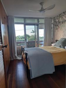 a bedroom with a bed and a large window at Brisbane 1960s Pool House - hosted bed and breakfast in Brisbane