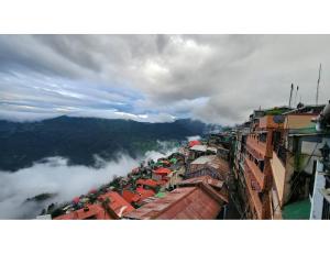 - une vue sur une ville avec brouillard dans les montagnes dans l'établissement Indus Mount Royale Hotel And Spa, Darjeeling, à Darjeeling