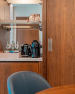 a kitchen with a coffee maker on a shelf at Abesq Doha Hotel and Residences in Doha