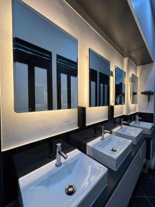 a row of sinks in a bathroom with mirrors at POTATO Boutique Hostel in Singapore +17 photos