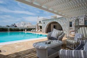 een patio met stoelen en een zwembad bij Villa Dionysos in Aliki in Aliki