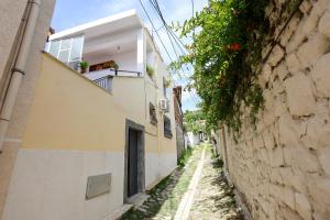 un callejón con un edificio y una pared en Guesthouse Berati, en Berat