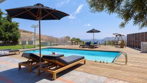 una piscina con 2 tumbonas y una sombrilla en Casa Blue Villa in Crete, en Agia Pelagia