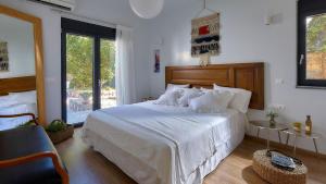 una habitación con una cama grande con sábanas y almohadas blancas en Casa Blue Villa in Crete, en Agia Pelagia