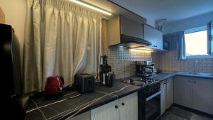 a kitchen with a counter top with a stove and a window at Rooftop Loft with Hydromassage in Volos +47 photos