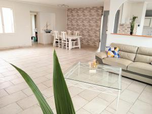 a living room with a couch and a table at Maison spacieuse proche de la Mer in Échillais