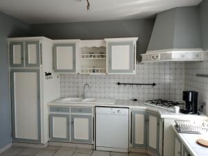 a kitchen with white cabinets and a sink at Maison spacieuse proche de la Mer in Échillais +11 photos